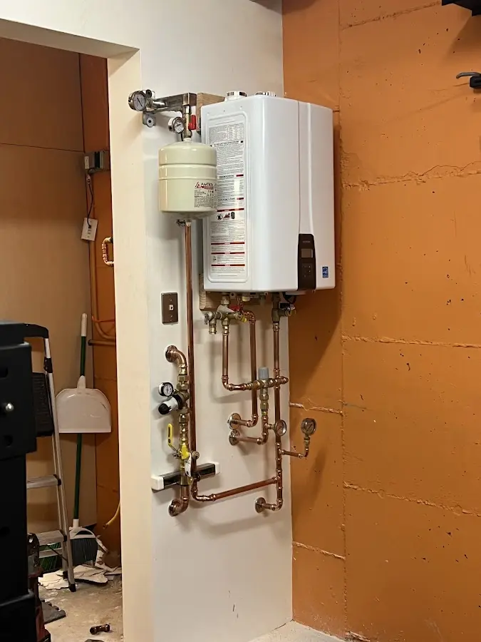 Plumbing technician inspecting water heater connections in Pleasant View